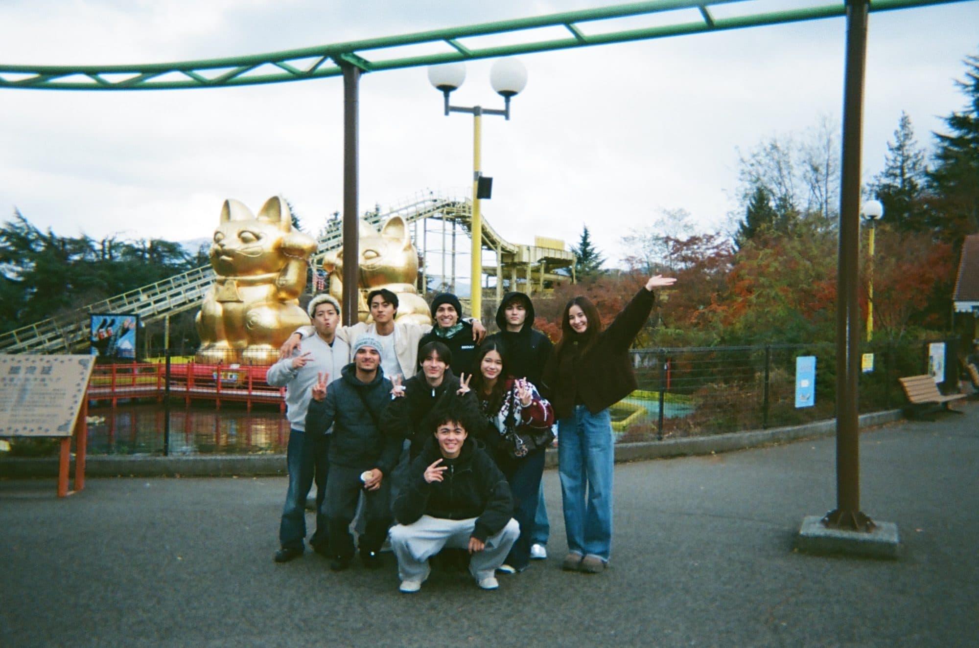 The crew gathered under the giant lucky cat