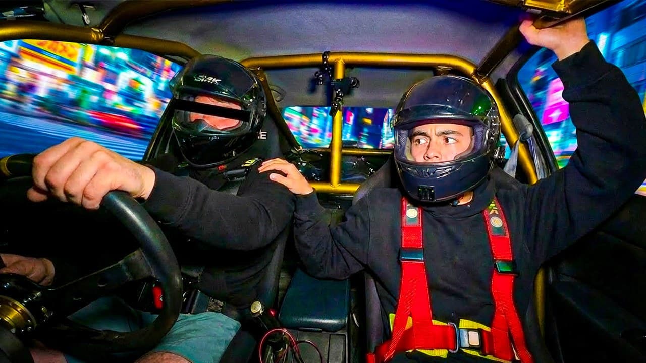 Owen gripping the roll cage inside the drift car in Tokyo