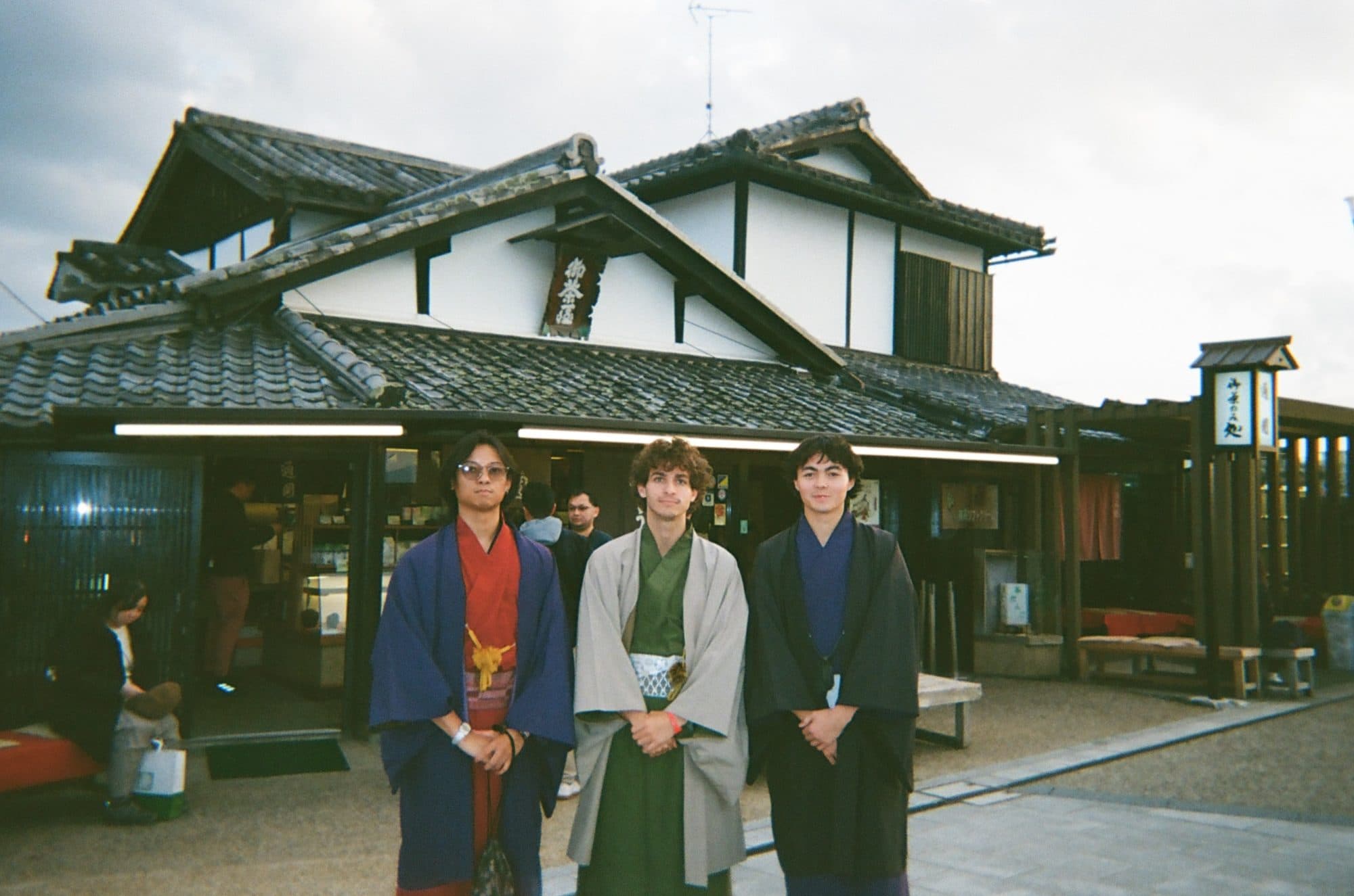 In traditional dress outside an old Japanese house at golden hour