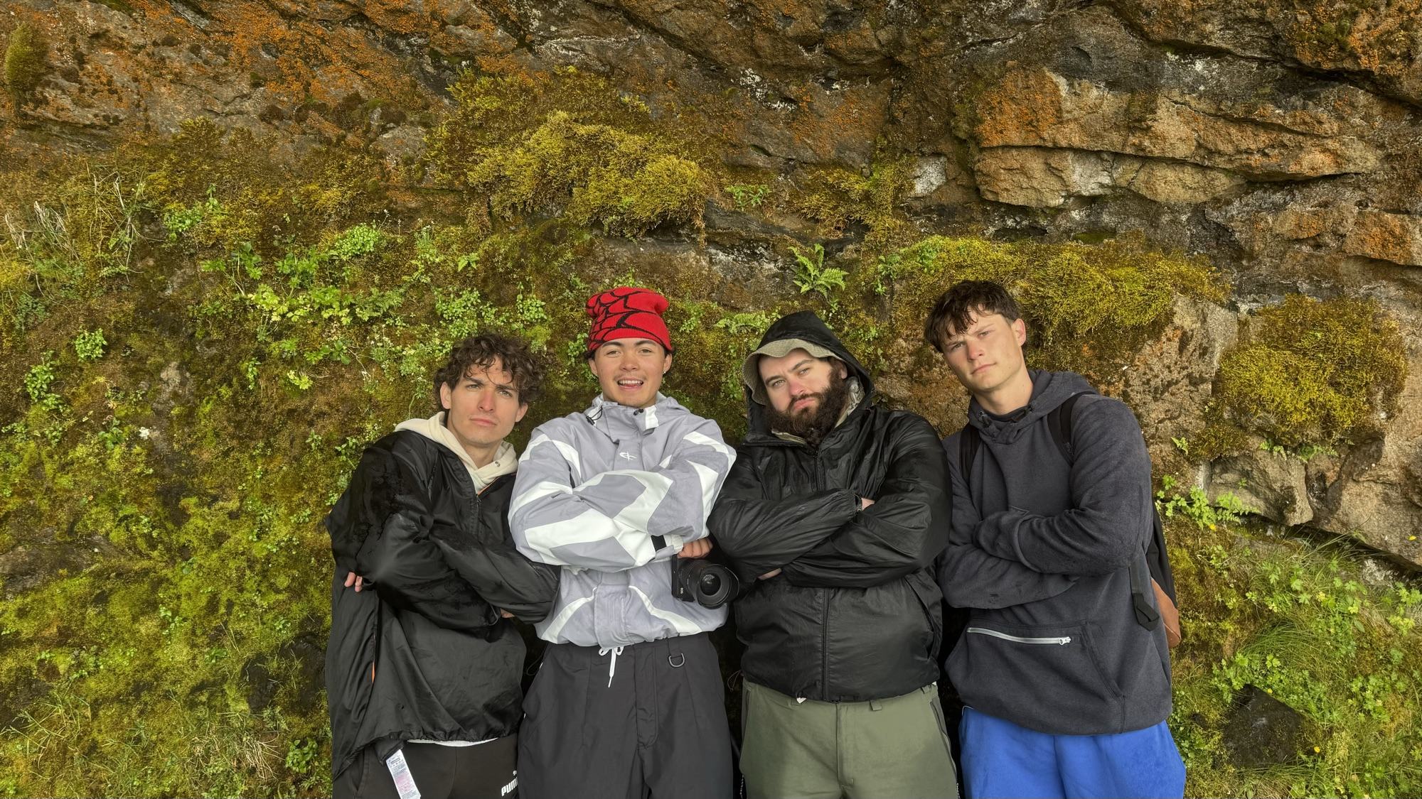 The Real Treasure crew gathered against a mossy cliff in Iceland