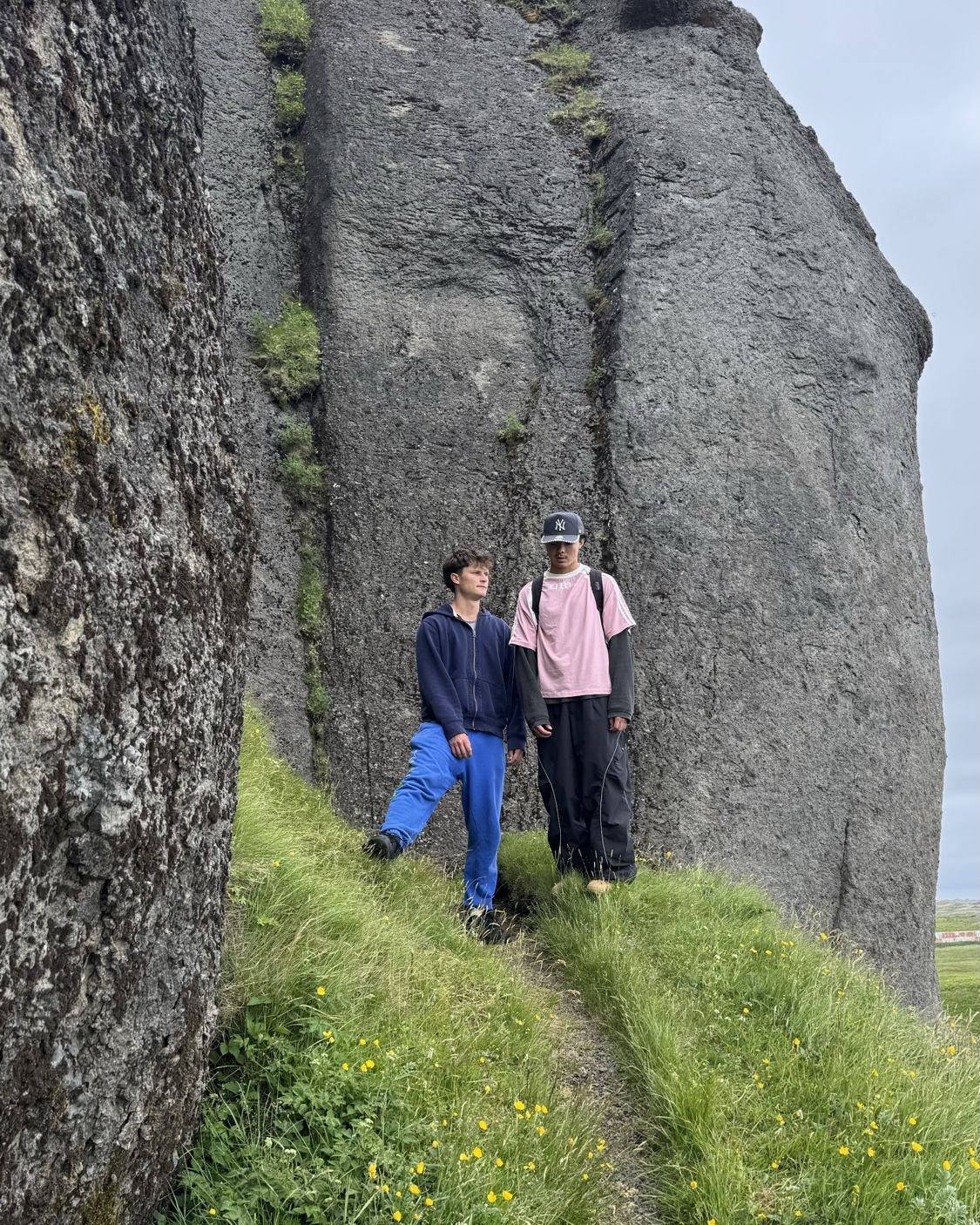 Walking the narrow passage through a giant split rock in Iceland