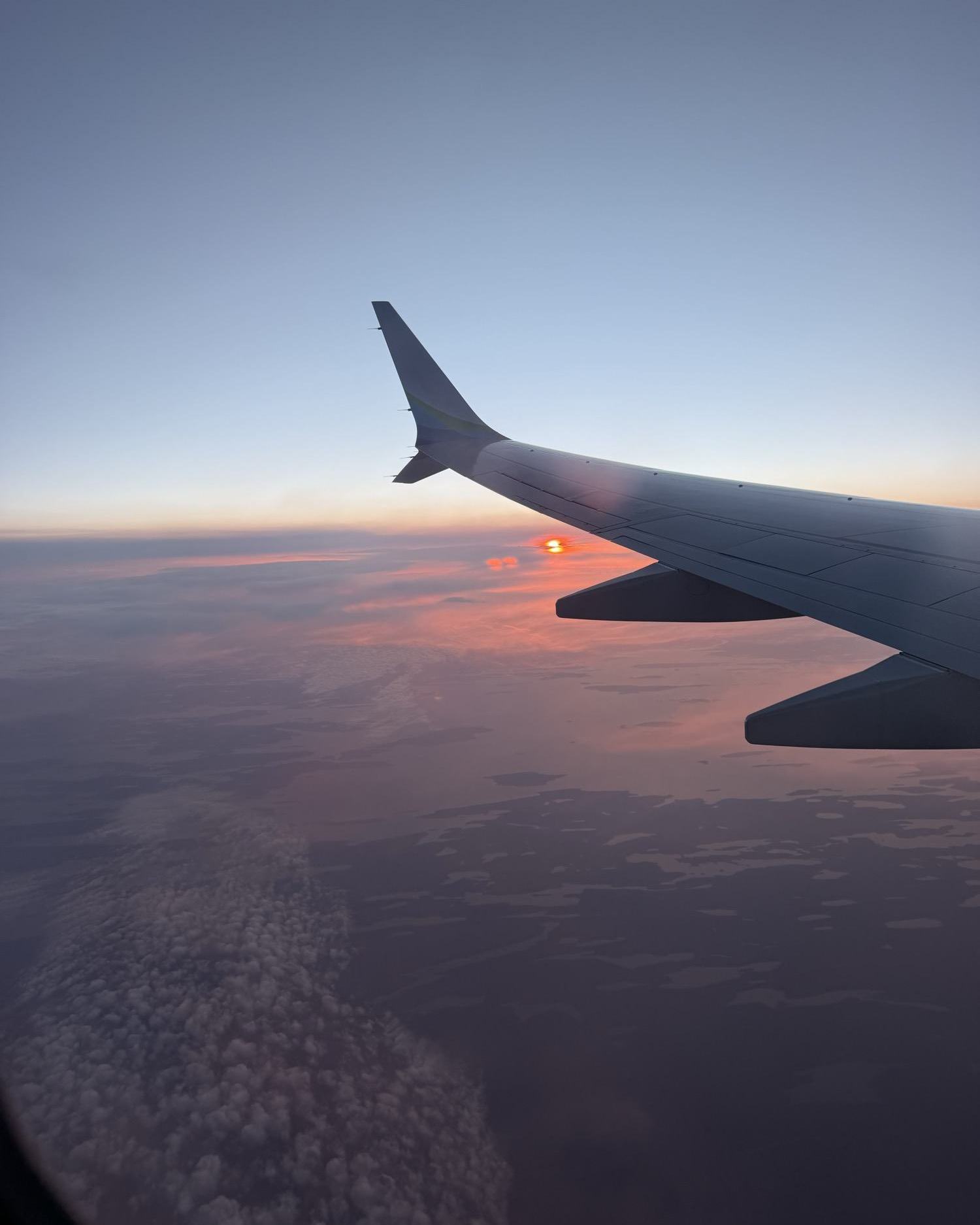 Sunset over the clouds from the plane window on the way to Iceland